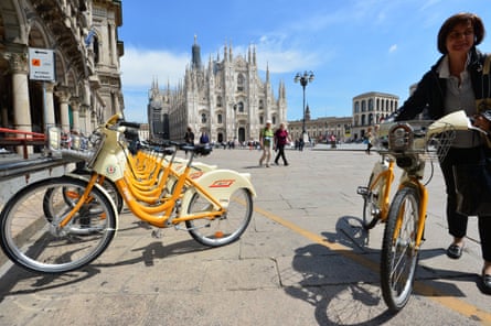 Cyclist using public bike share, Milan.