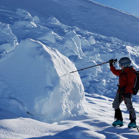 Sam Noble presses his snow stick into a large boulder of snow higher than his head
