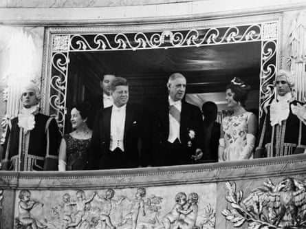 Yvonne de Gaulle, John F Kennedy, Charles de Gaulle and Jackie Kennedy connected an ornate balcony, flanked by footmen
