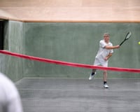 Man holding racket moves to hit ball