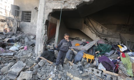 Child standing amid rubble of newly destroyed building.