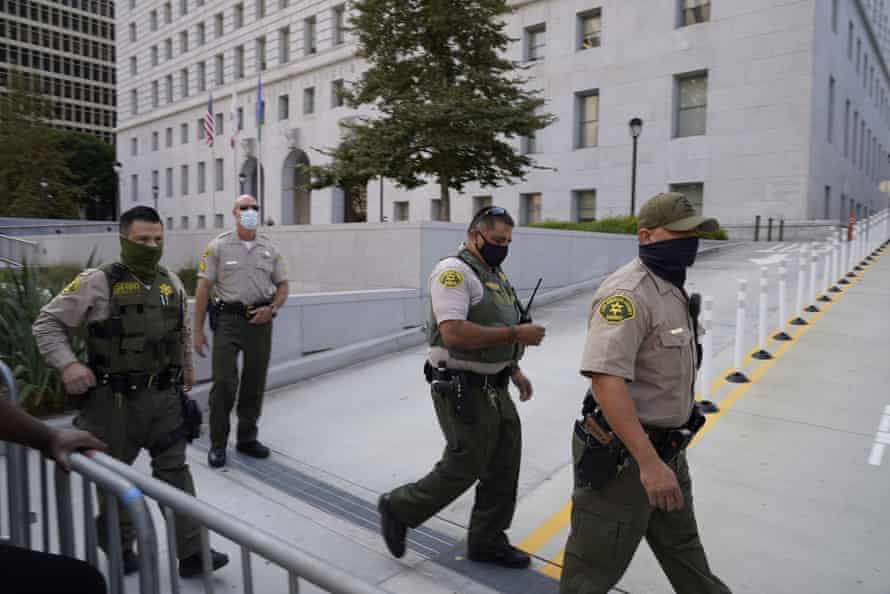 Sheriff's deputies walk next to a barrier outside the hall of justice.
