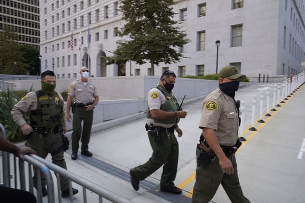 Sheriff’s deputies walk next to a barrier outside the hall of justice.