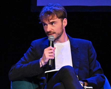 Antoine Bristielle speaking into a microphone while sat on a stage
