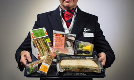 A BA cabin crew member holds up the new M&S menu