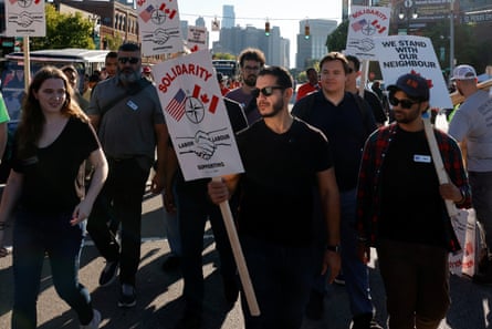 A man with a pro-labor sign walks among a crowd