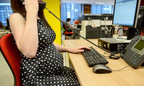 Pregnant woman working at office desk.