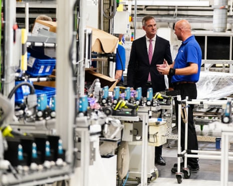 Two men speak in a factory