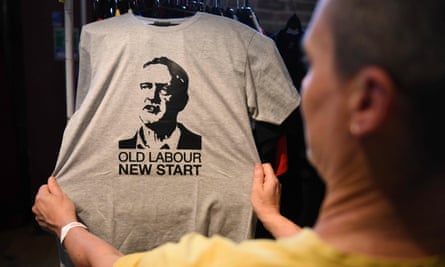 A supporter of Momentum looks at a T-shirt showing Corbyn’s face during the Labour party conference in Liverpool.