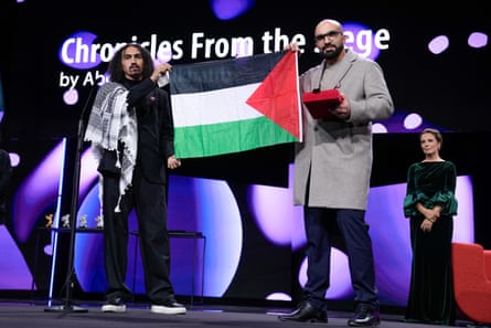 Abdallah al-Khatib (left) and Taqiyeddine Issaad holding a Palestinian flag on stage