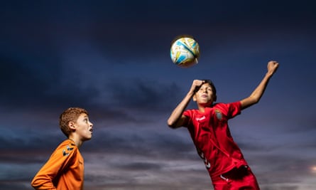 Twins Yaser el Tahiri and Yassin el Tahiri jump in the air with a football above their head