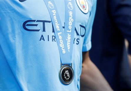 A Manchester City player with his medal as he celebrates winning the Premier League title