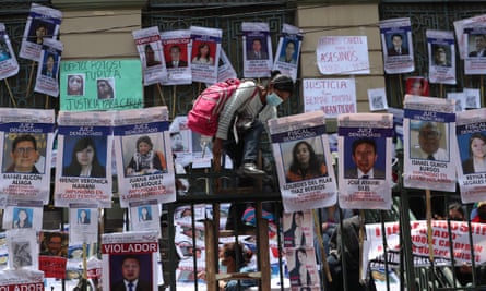 A woman climbs the bars – which are covered portraits and information of accused or convicted of rape and murder and/or judges and prosecutors who have released those involved in cases of sexist violence or femicide – of the Departmental Court of Justice in La Paz, Bolivia.