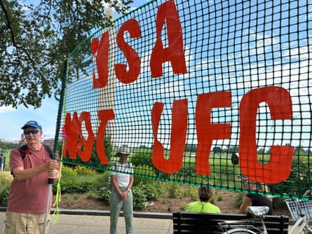 group of people standing outside holding net marked ‘USA not UFC’