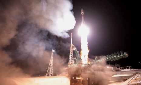 A Soyuz-2.1b rocket booster with a Fregat upper stage and OneWeb satellites blasts off from a launchpad at the Baikonur Cosmodrome.