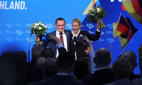Alice Weidel, co-leader and chancellor candidate of the far-right Alternative for Germany (AfD), and AfD co-leader Tino Chrupalla stand on stage with flowers at AfD headquarters after the announcement of initial results in the snap federal parliamentary elections.
