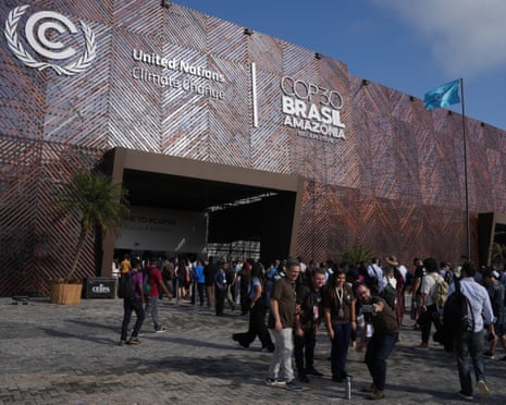People pose for photos outside the entrance to the Cop30 venue