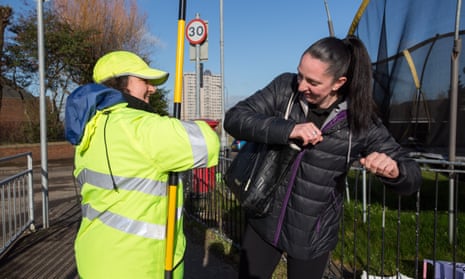 A lollipop lady does an elbow bump with a mother who has dropped her child off at school in Glasgow back in March just before full lockdown measure were imposed.