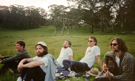 Members of the band Fig sit on a lawn