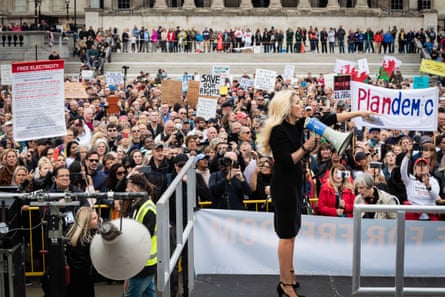 A woman with a megaphone addresses a crowd of protesters.