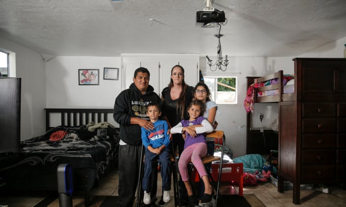 Víctor, de 29 años, y Nicole, de 26 años, posan con sus hijos: Víctor, cuatro; Sherlin, nueve; Y Jasmine, de ocho años, en el garaje de coches donde han vivido durante los últimos tres años, en Menlo Park, California.