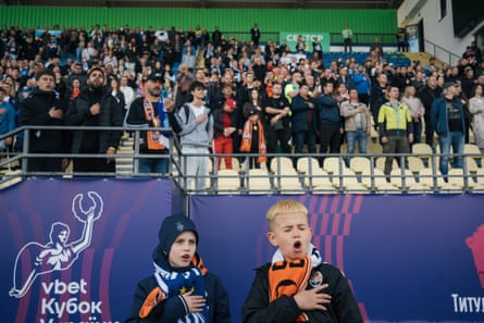 Ukrainian fans sing the national anthem before the game starts