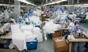 Workers produce protective clothing at a factory that previously produced suits and sportswear, in Wuxi in China’s eastern Jiangsu province.