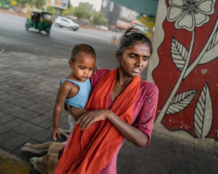 A young woman holds a baby on her hip.