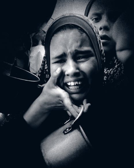 A woman wears a distressed expression as she holds her palm to her chin with a food pan hanging from her fingers by its handle