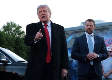 Donald Trump pointing as he speaks to reporters