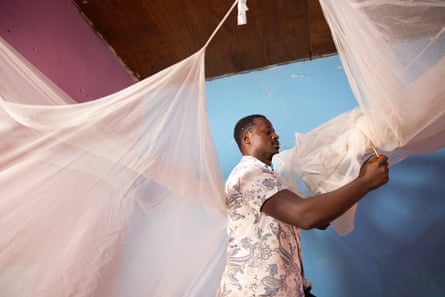 A man assembles a dual insecticide-treated mosquito net in his home in Soa, near Yaoundé, Cameroon.