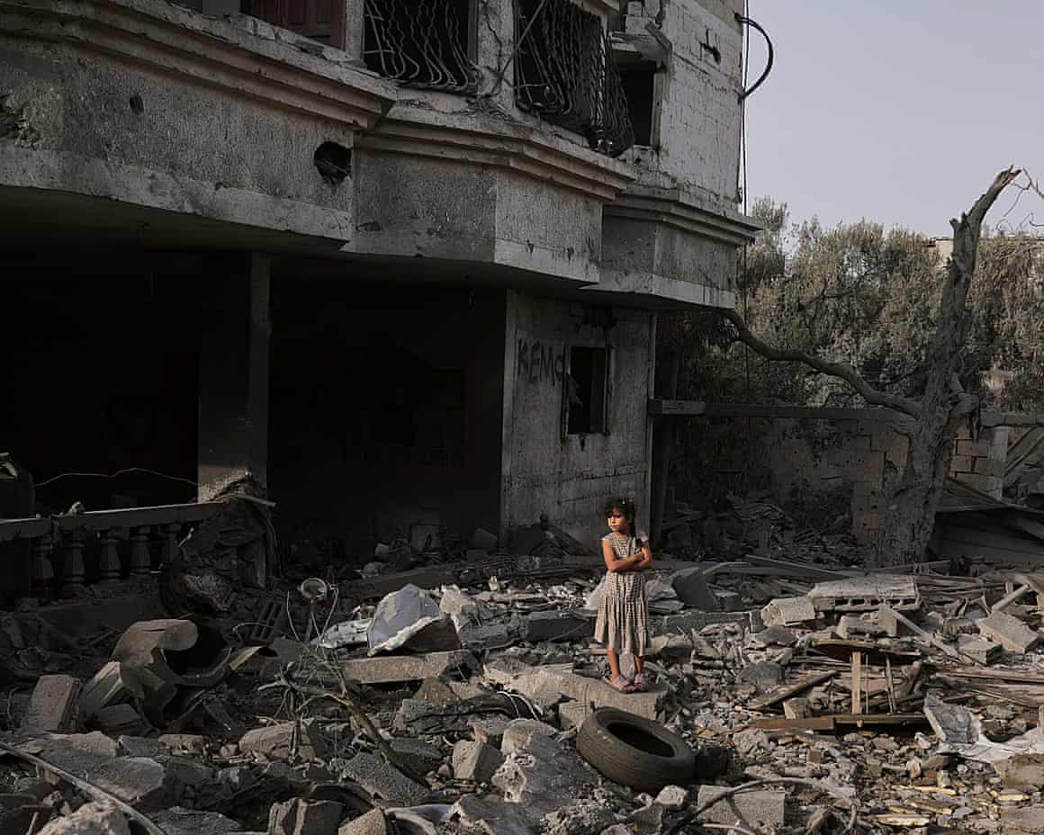 A girl stands atop rubble