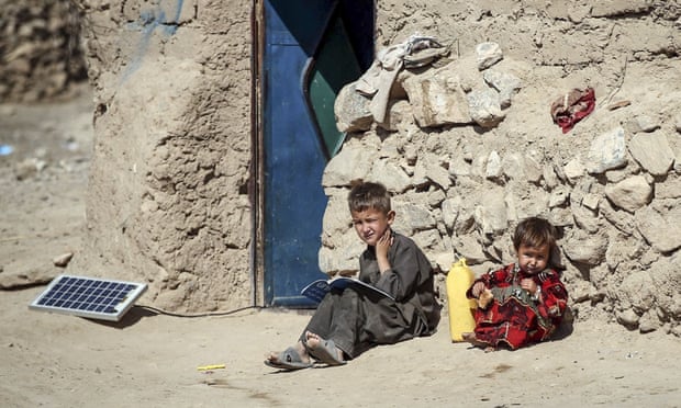 Two children read books in front of a door on the outskirts of Herat, Afghanistan on 15 October 2015.