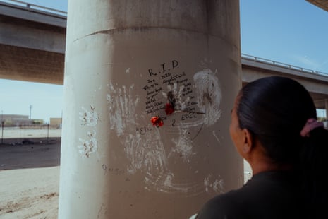 A woman looks at written memorial on a concrete column