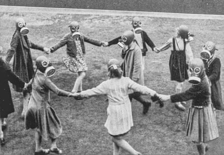 German children play in 1937 while wearing gas masks.