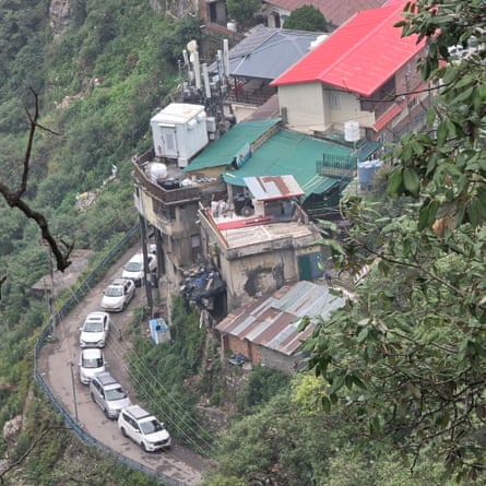 A line of cars bumper to bumper on a narrow hillside road
