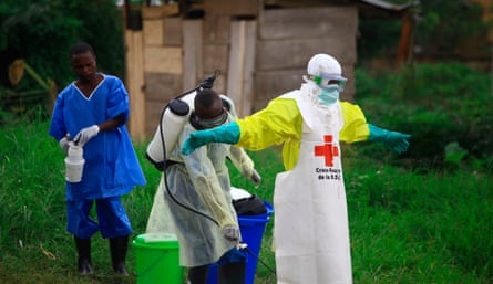 A health worker sprays disinfectant on his colleague after working at an Ebola treatment center in eastern Congo