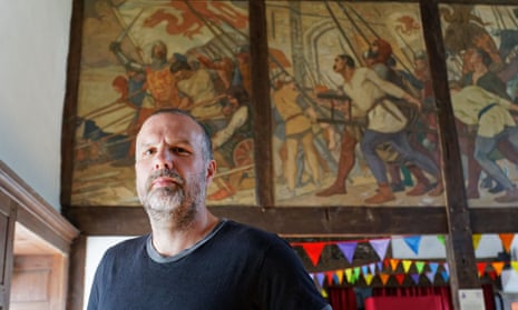 Huw Morgan stands in front of a mural in the parliament building in Machynlleth depicting Owain Glyndŵr’s final victory against the English in 1401.