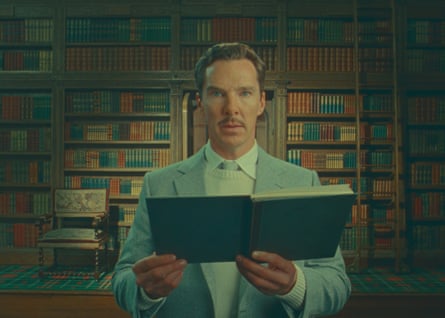 Benedict Cumberbatch wears a light coloured suit in a packed library.