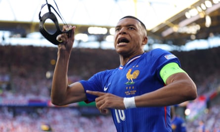 Kylian Mbappé takes off his protective mask after his penalty gave France the lead.