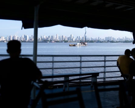 Apartment blocks and other tall buildings in the distance across a wide river.