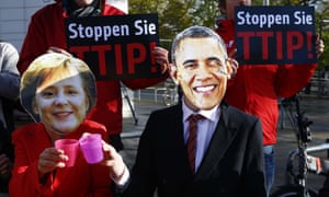 Protesters wear masks of Barack Obama and Angela Merkel as they demonstrate against TTIP free trade agreement
