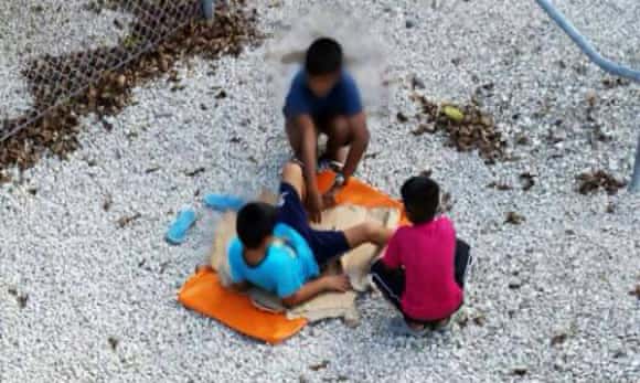 Children playing near a fence at the Nauru detention centre