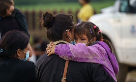 A woman holds her daughter while waiting to be processed by US border patrol after crossing the US-Mexico border in July. 