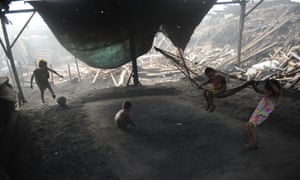 Children playing football on an open stove used for smelting woods into charcoal at an unregulated charcoal factory locally known as ‘Ulingan’ in the slums of Manila, Philippines.