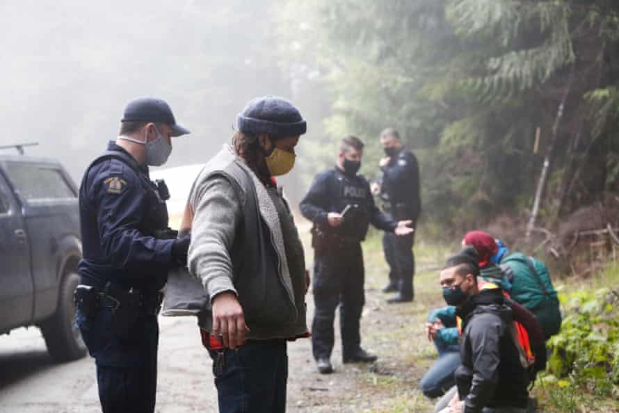 Police search protesters after their arrest.