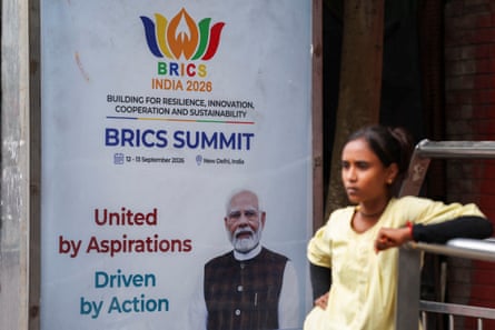 A girl stands next to a poster featuring Indian prime minister Narendra Modi ahead of the Brics summit