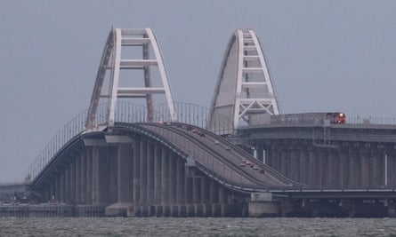 Tren de pasajeros y automóviles que circulan por el puente de Kerch después de que parte de él fuera destruido por una explosión