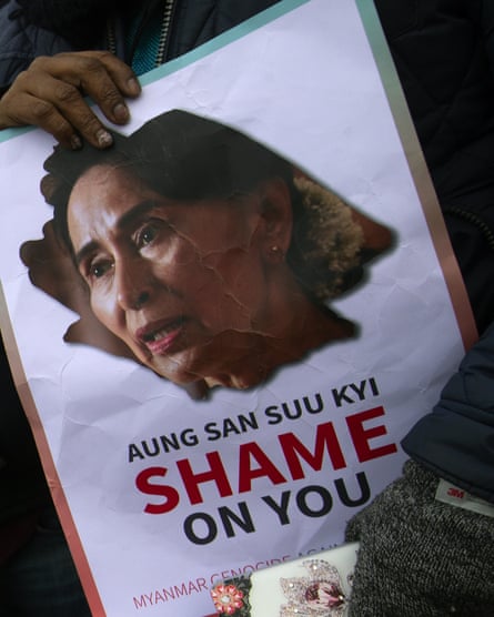 Demonstrators hold signs outside the international court of justice where Aung San Suu Kyi was attending the first of three days of hearings in The Hague.