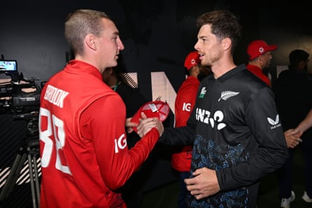 Harry Brook (left) and New Zealand captain Mitchell Santner shake hands after the abandoned T20 cricket international in Auckland